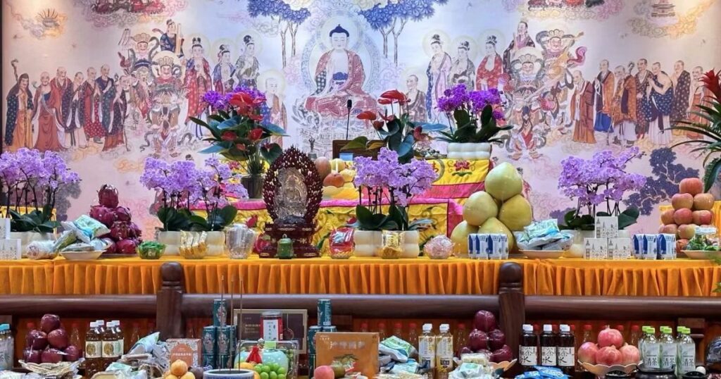 佛教盂蘭盆節祭壇供桌擺滿供品、鮮花與佛像